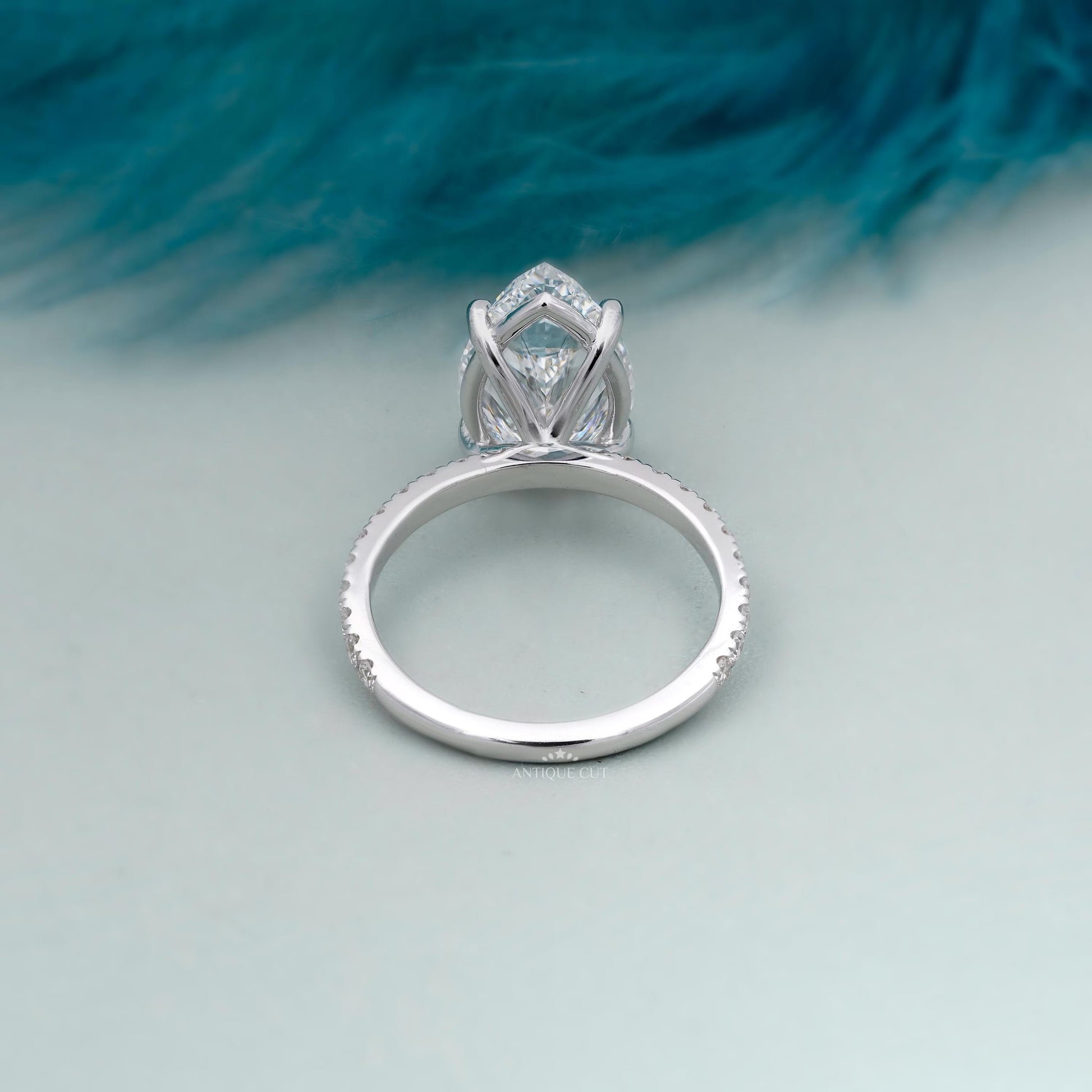 Antiquecut pear engagement ring with round side stones
