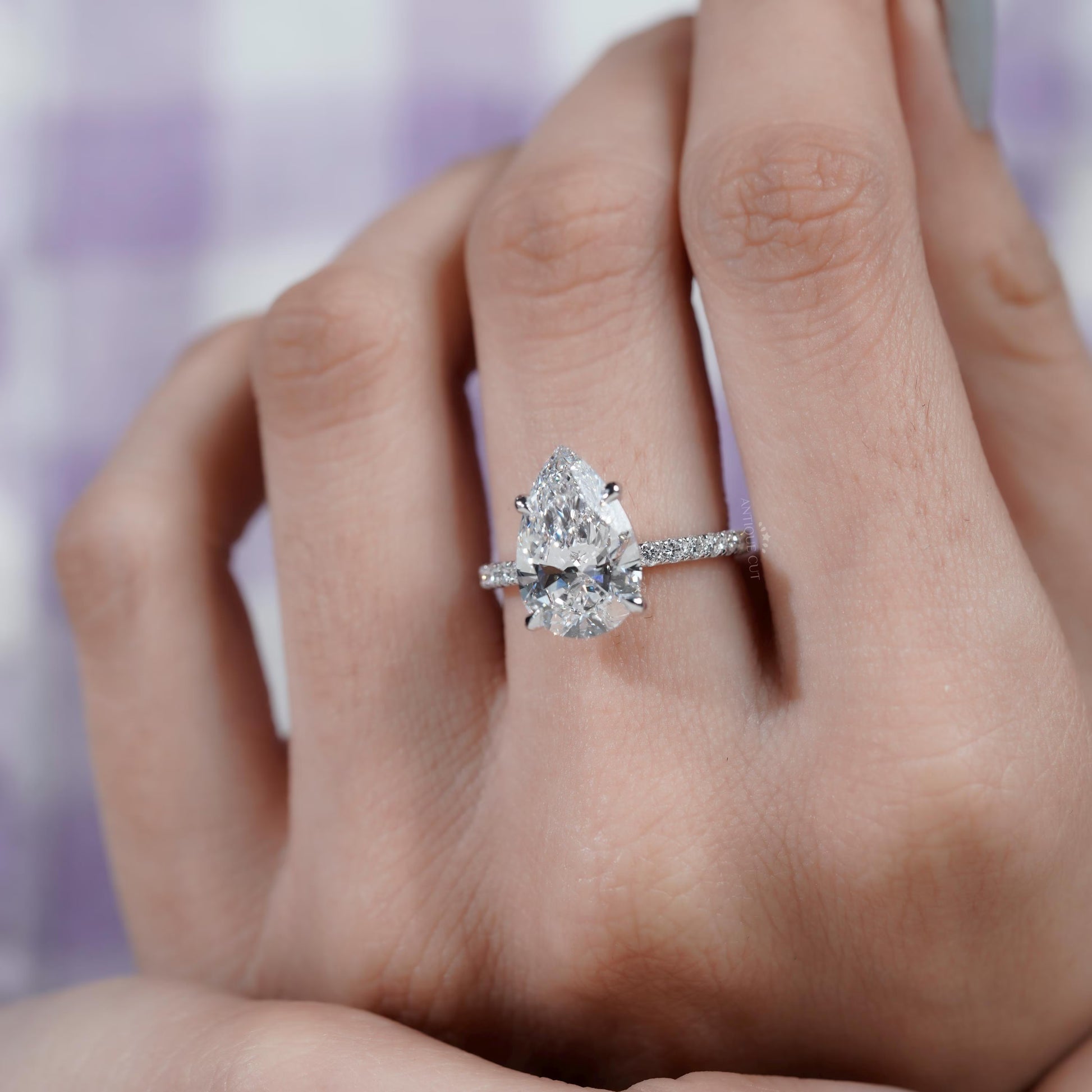 Brilliant pear shaped diamond ring with side stones