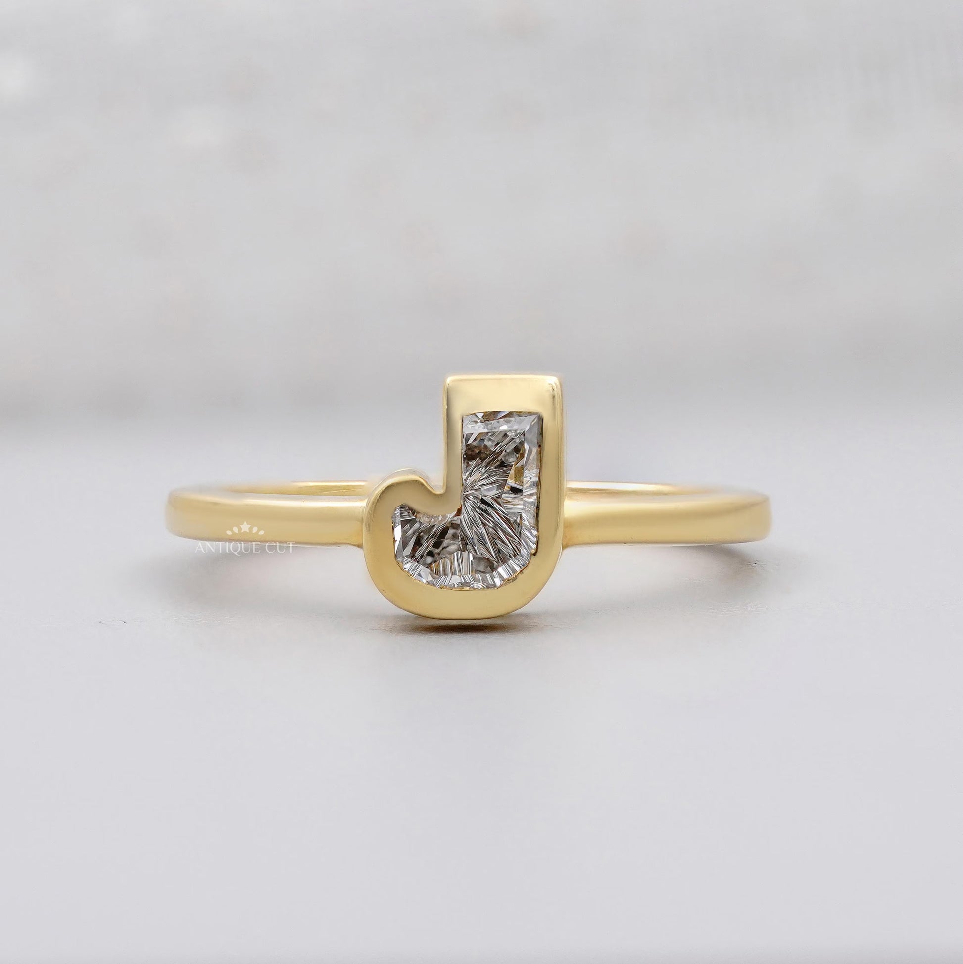 J shape initial design ring in yellow gold