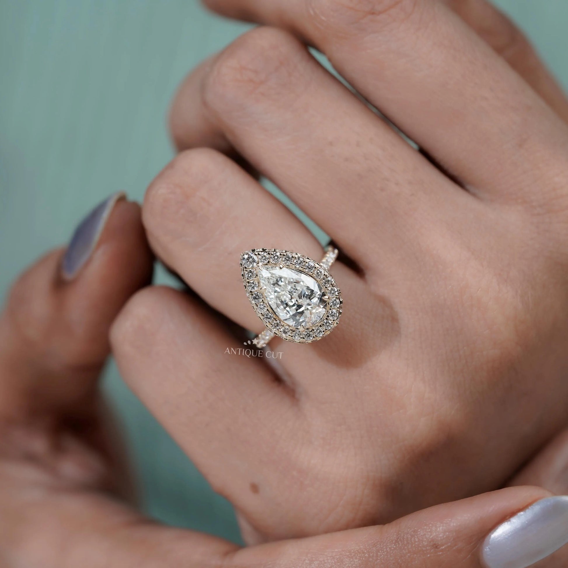 Modern pear engagement ring with pave band