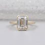 Emerald engagement ring bezel set in yellow gold
