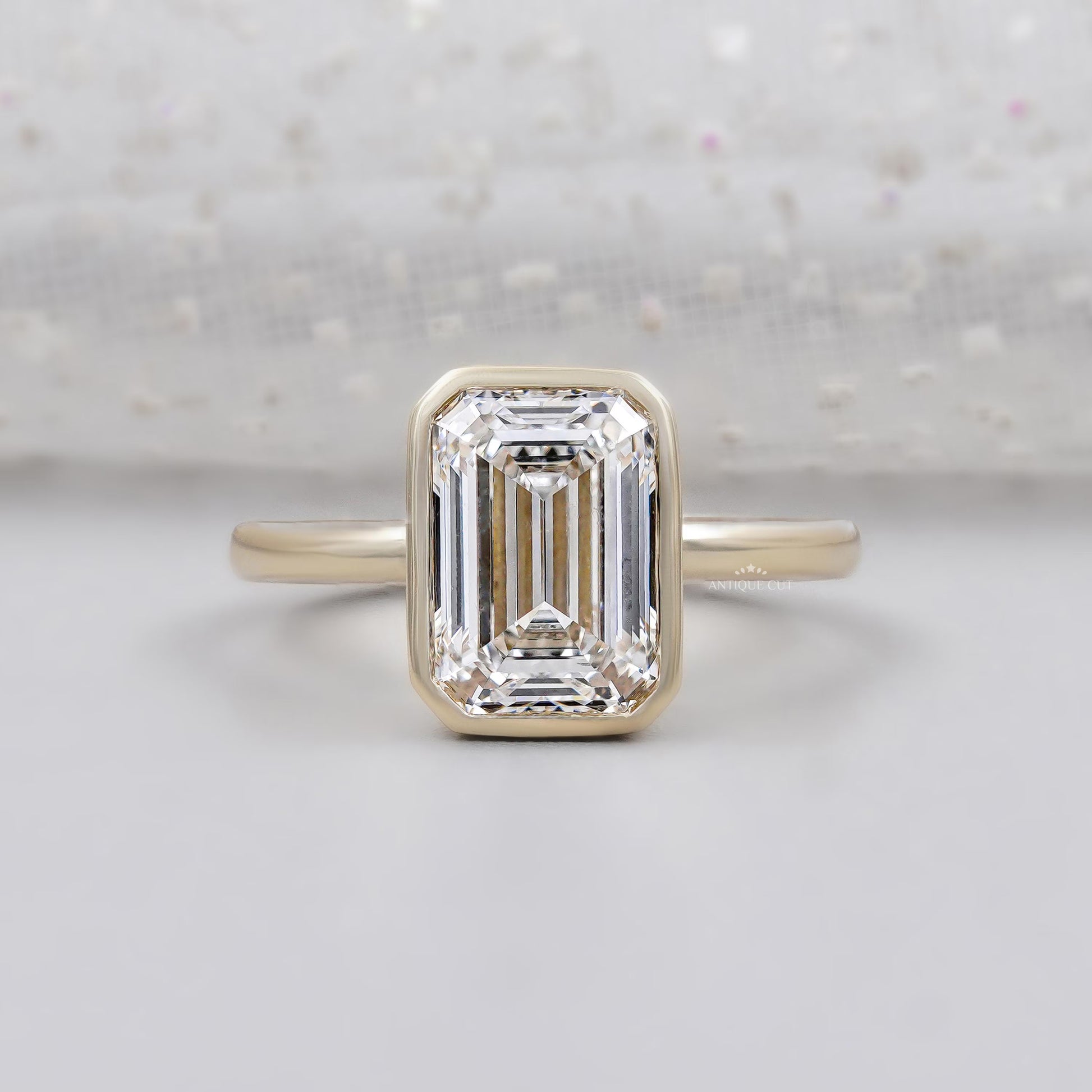 Emerald engagement ring bezel set in yellow gold
