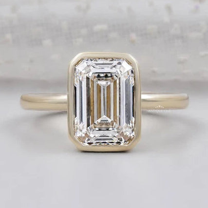 Emerald engagement ring bezel set in yellow gold