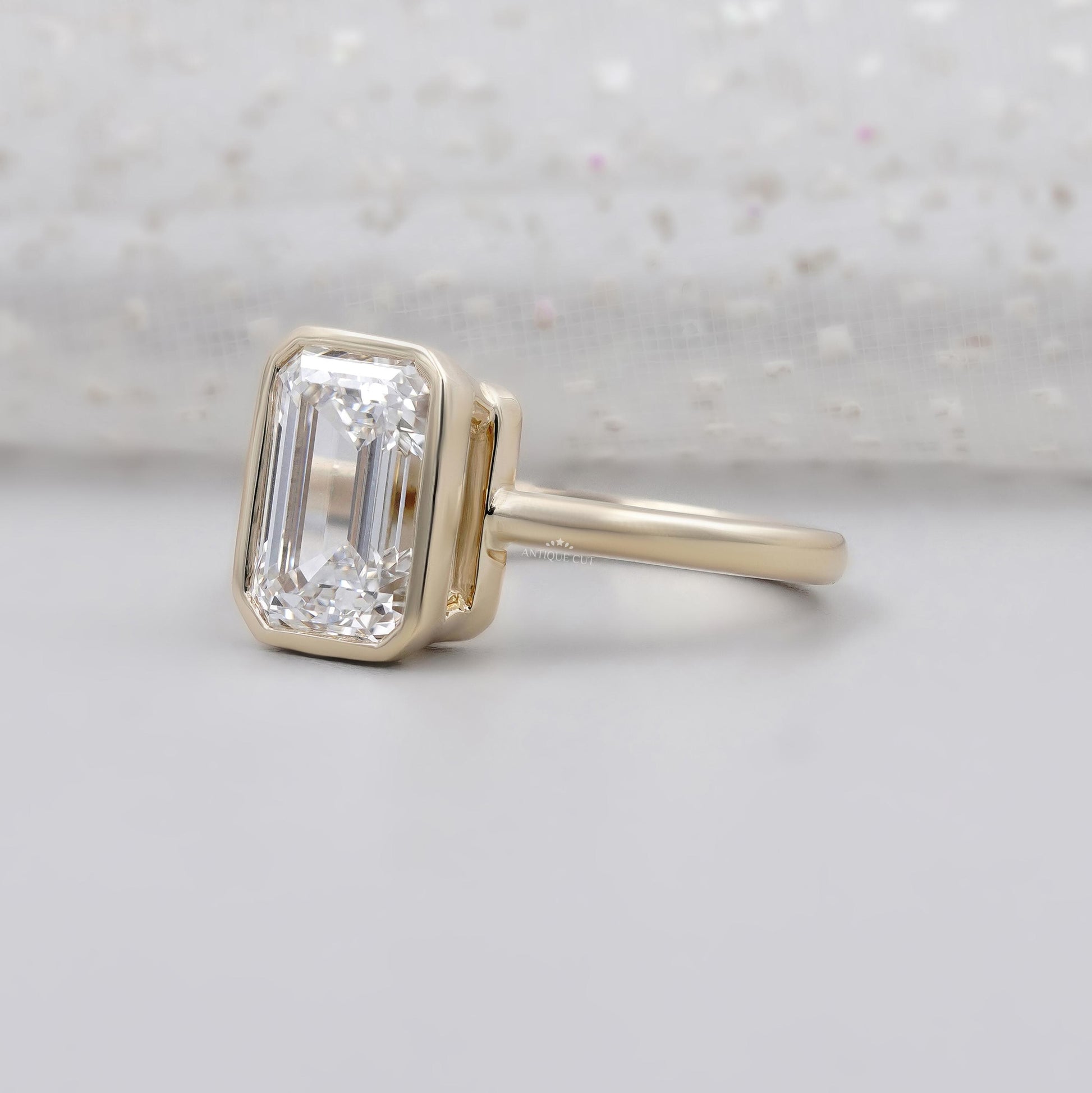 Yellow gold emerald diamond engagement ring with bezel setting