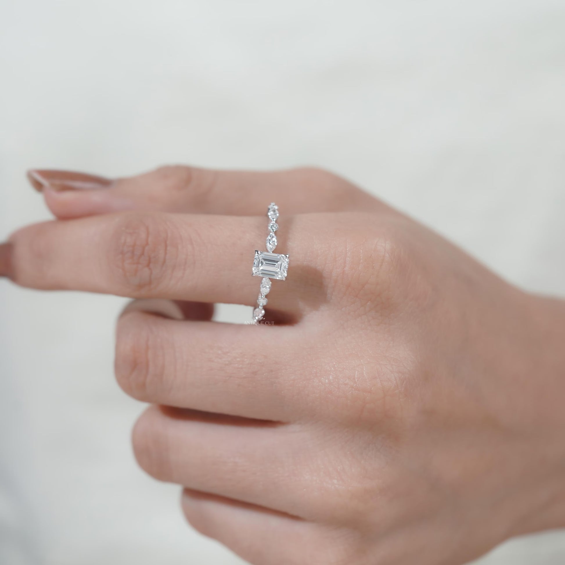 Minimalist emerald solitaire ring with diamond band
