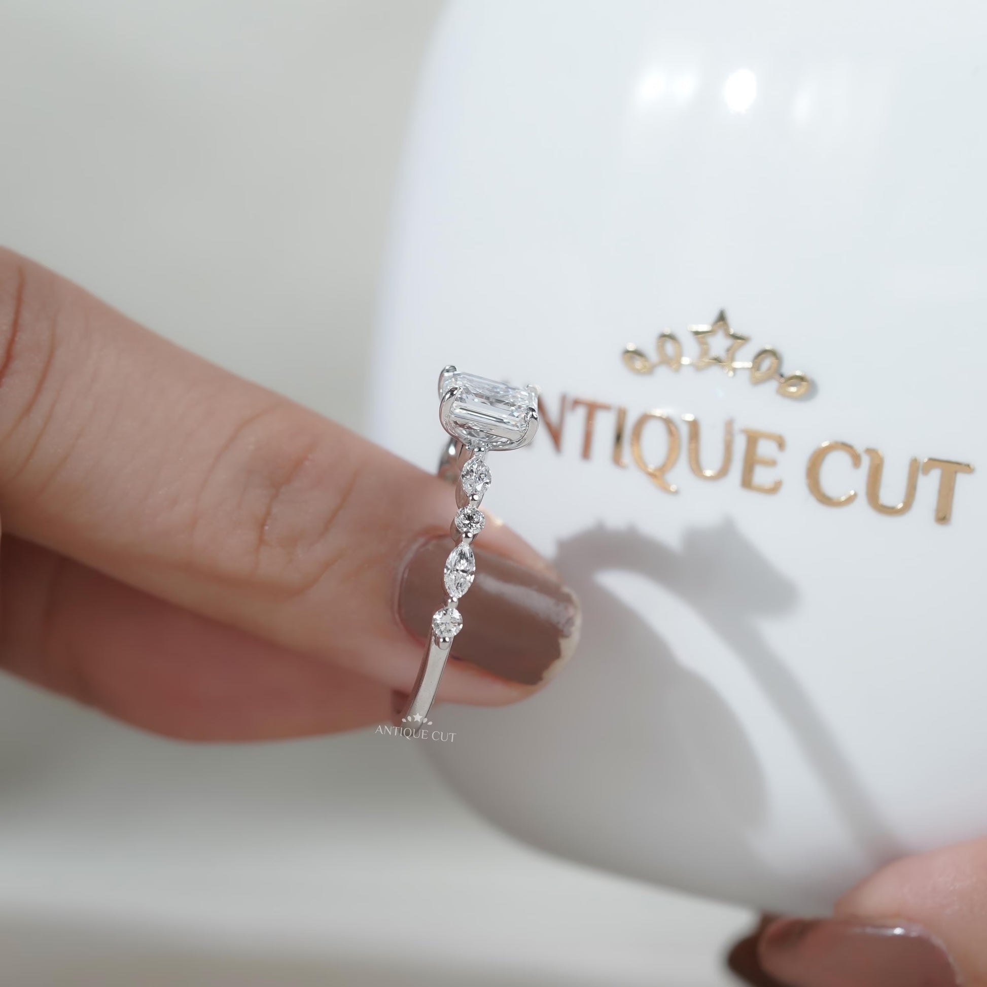 White gold bridal ring with emerald center stone and pave band