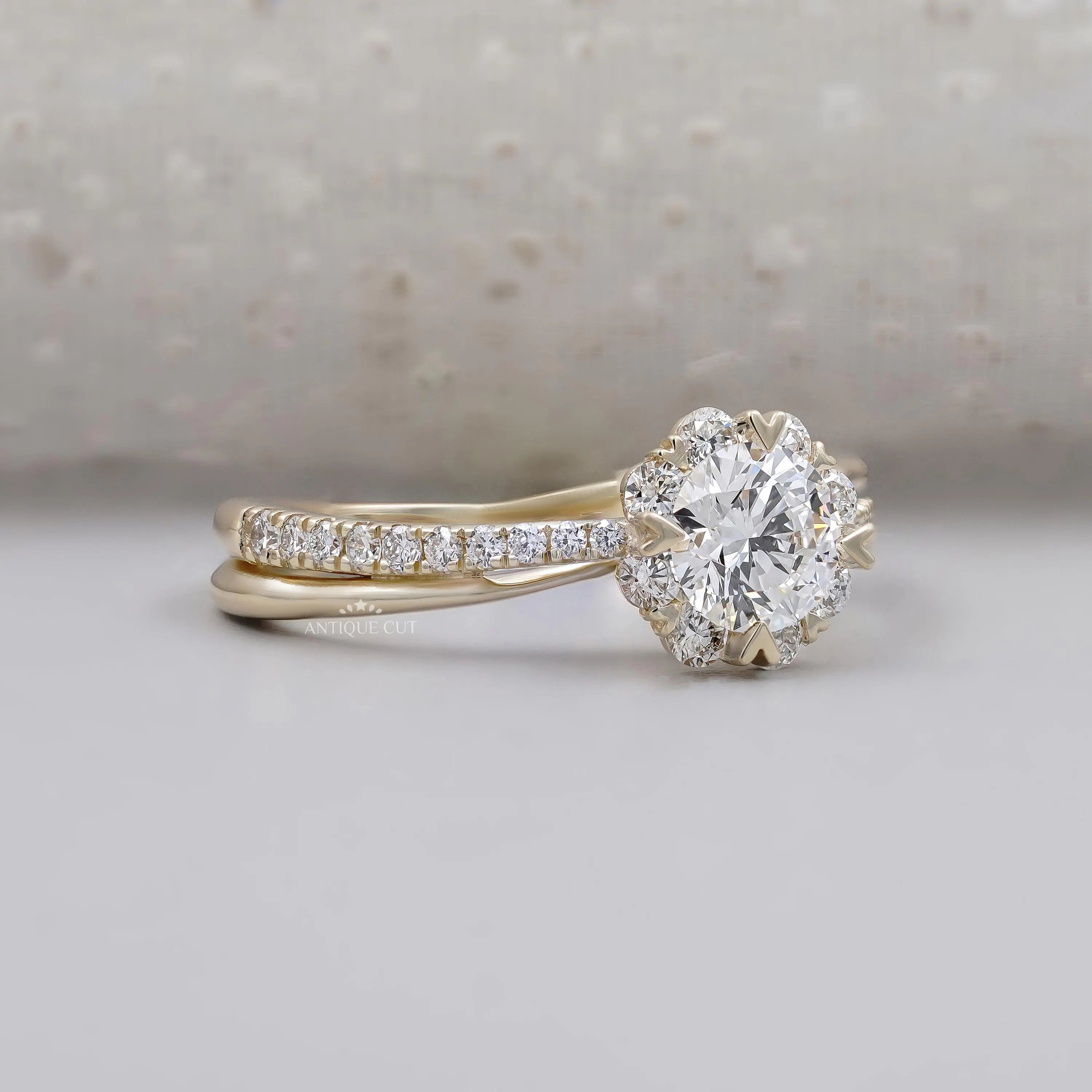 Round diamond engagement ring with floral halo and twisted band