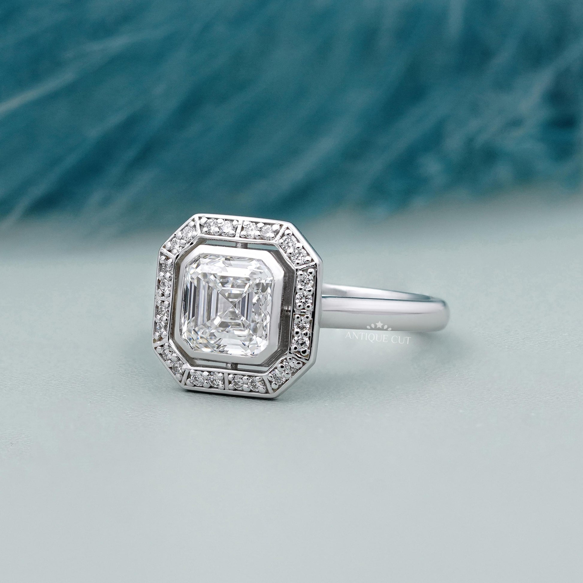 White gold Asscher diamond halo ring with bezel setting