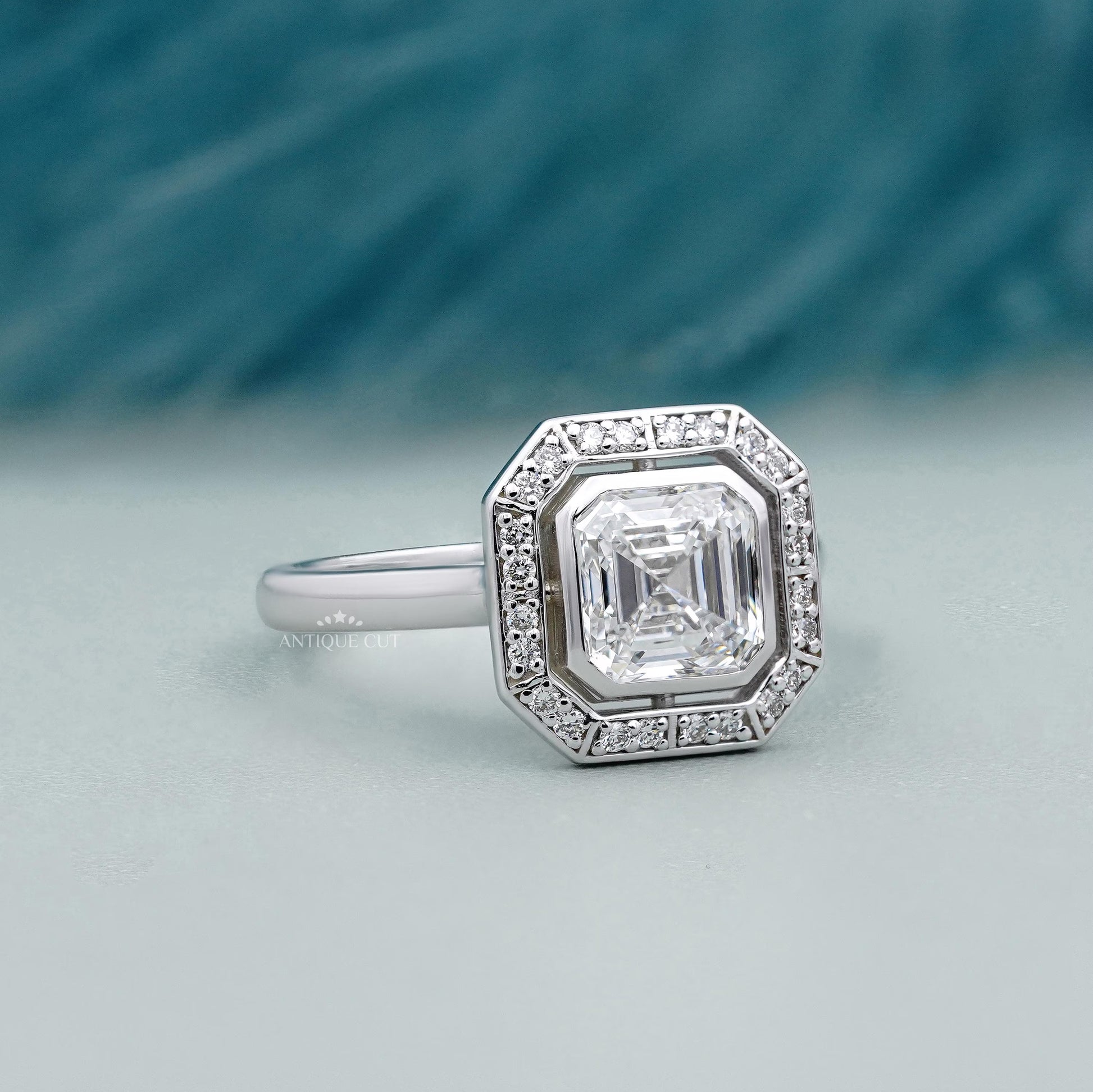 Asscher cut diamond bezel set halo engagement ring in white gold