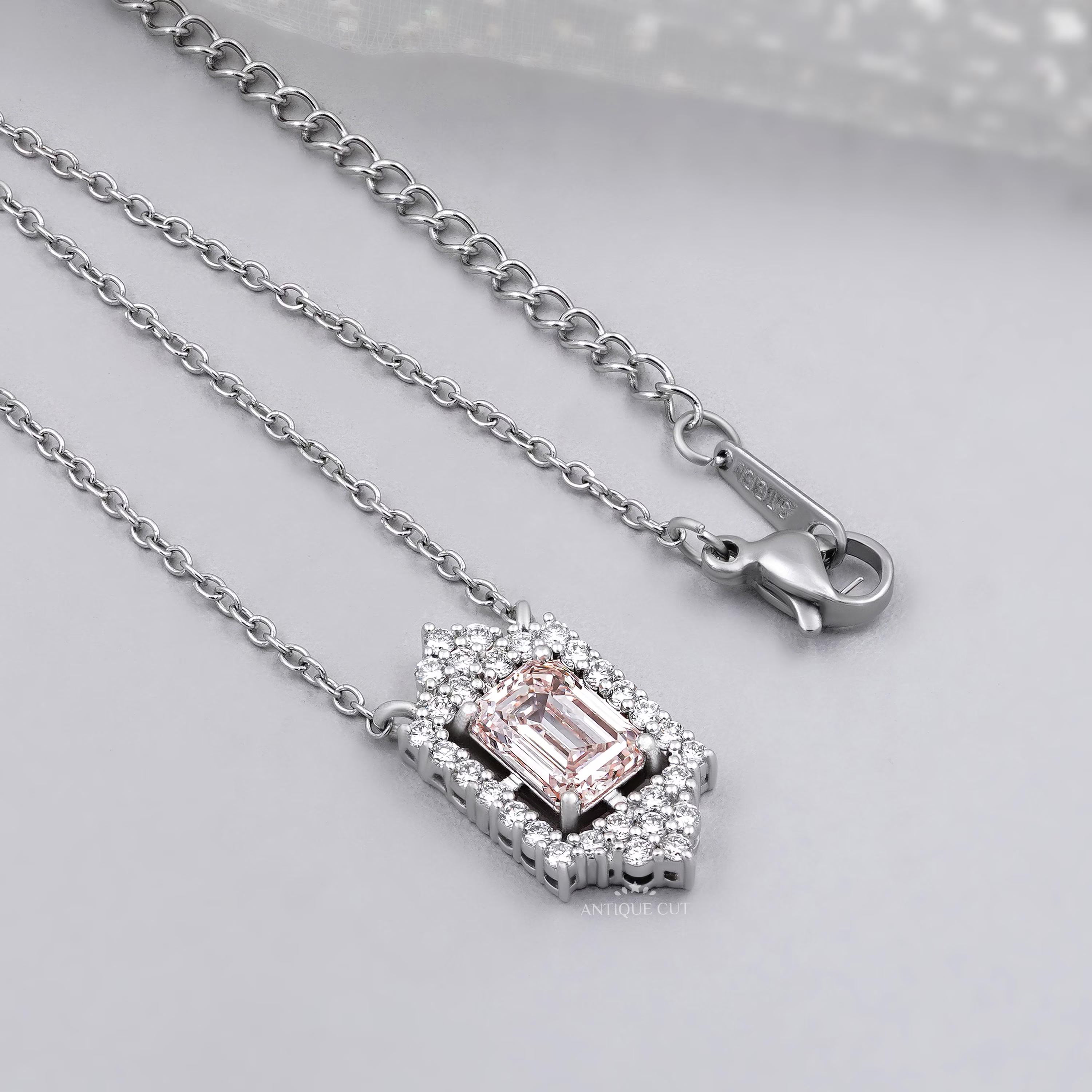White gold round diamond halo pendant with blush pink emerald