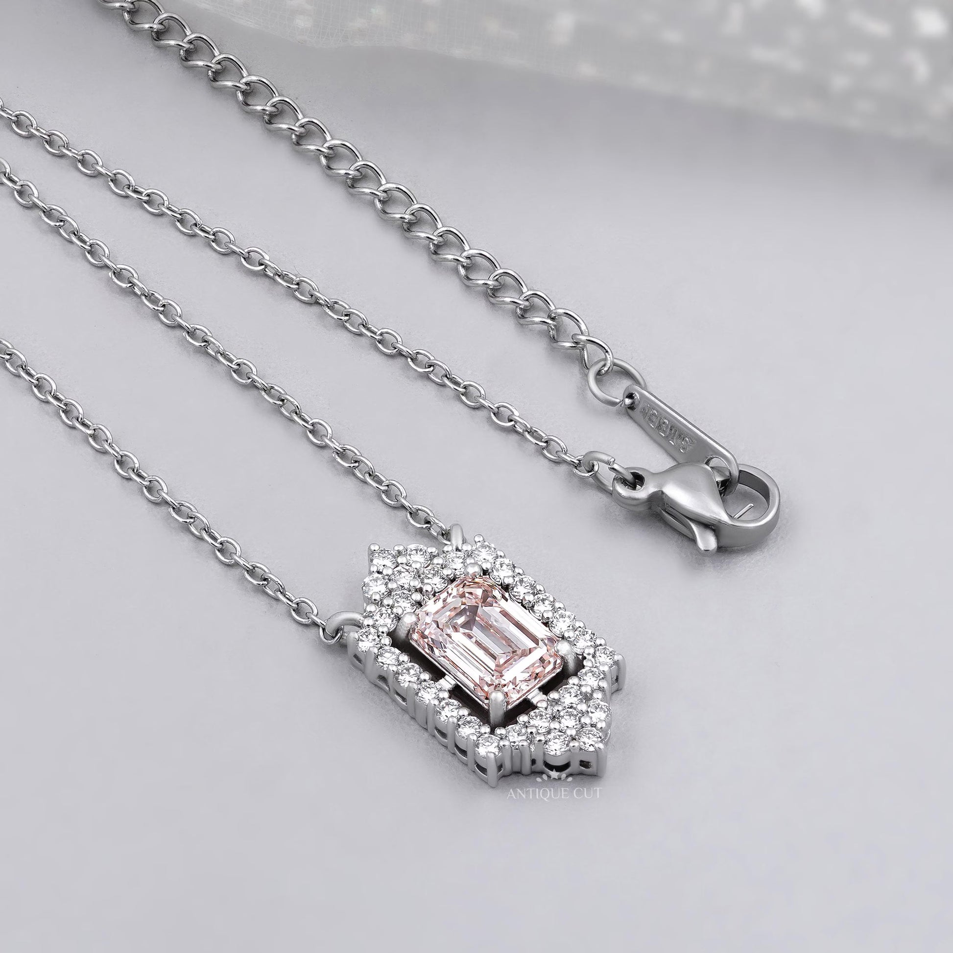 White gold round diamond halo pendant with blush pink emerald