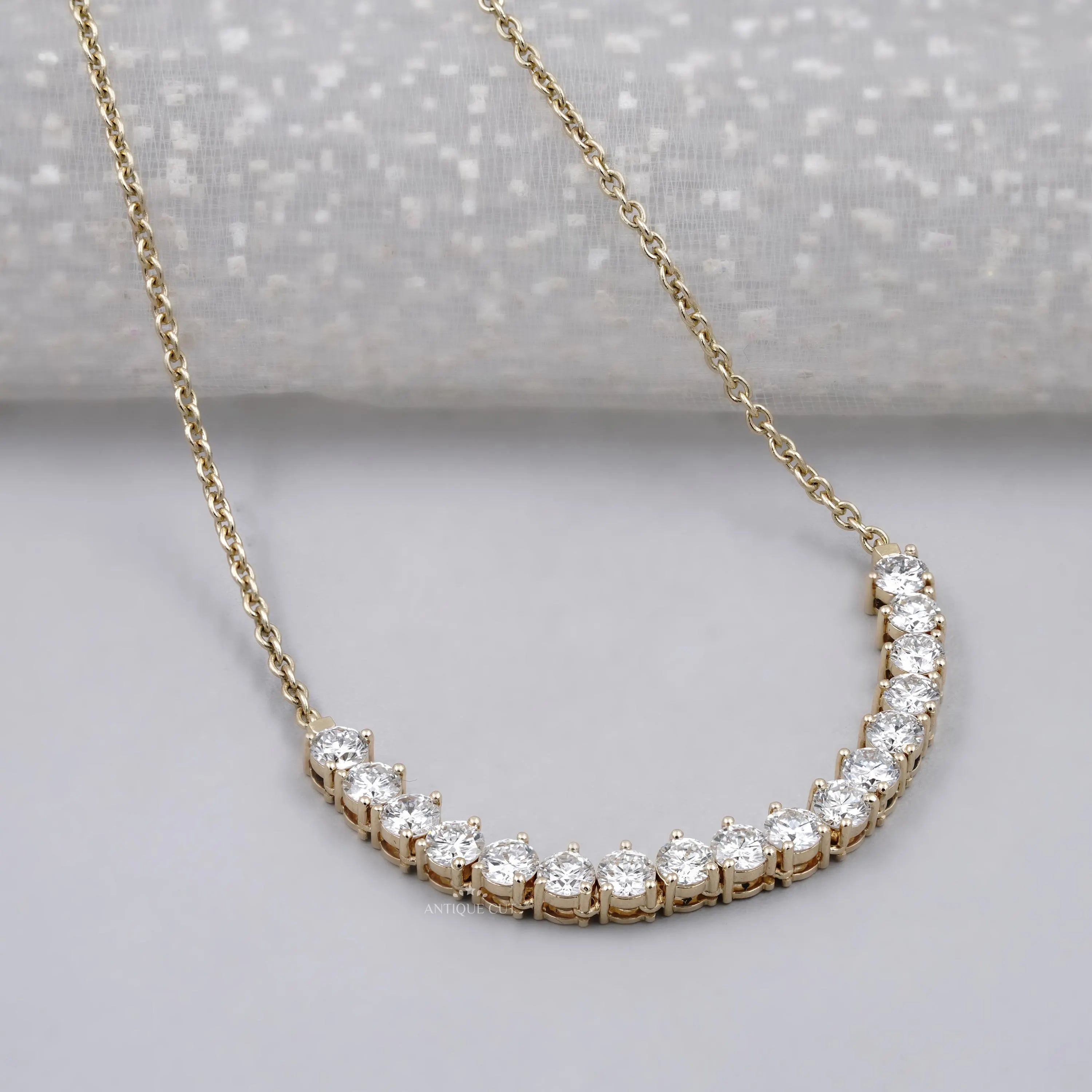 Yellow gold curved bar pendant with round diamonds