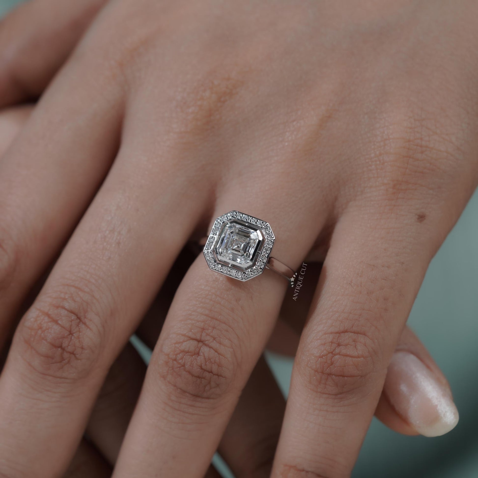 Asscher cut solitaire diamond ring with surrounding halo