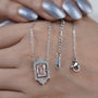 Round diamond halo pendant with blush pink emerald center