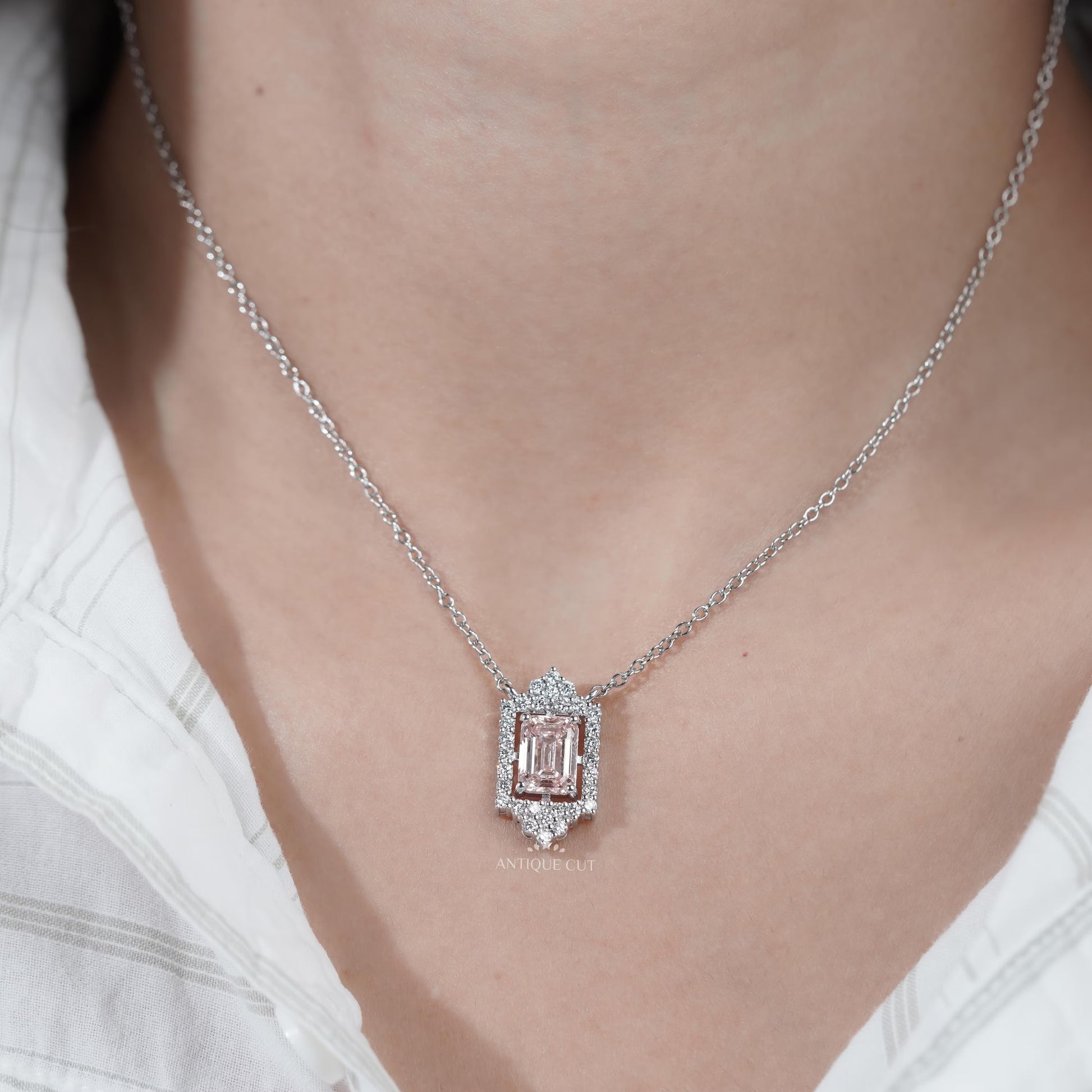Modern round diamond halo pendant with emerald