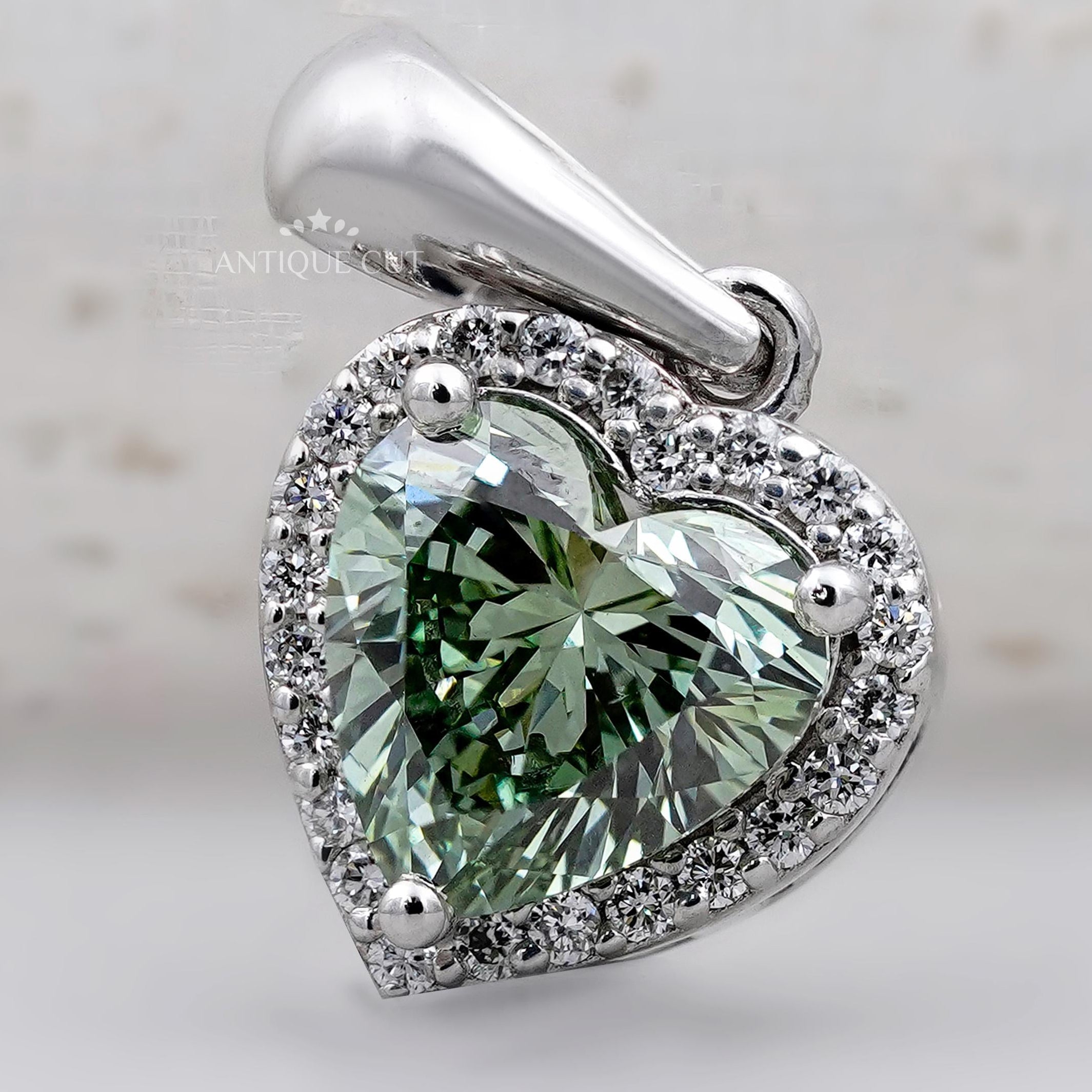 Green heart shaped diamond pendant with halo