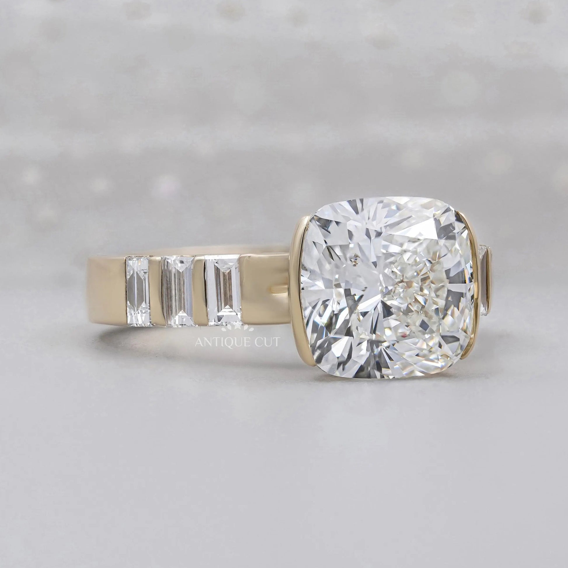 Cushion cut East West engagement ring with half bezel setting