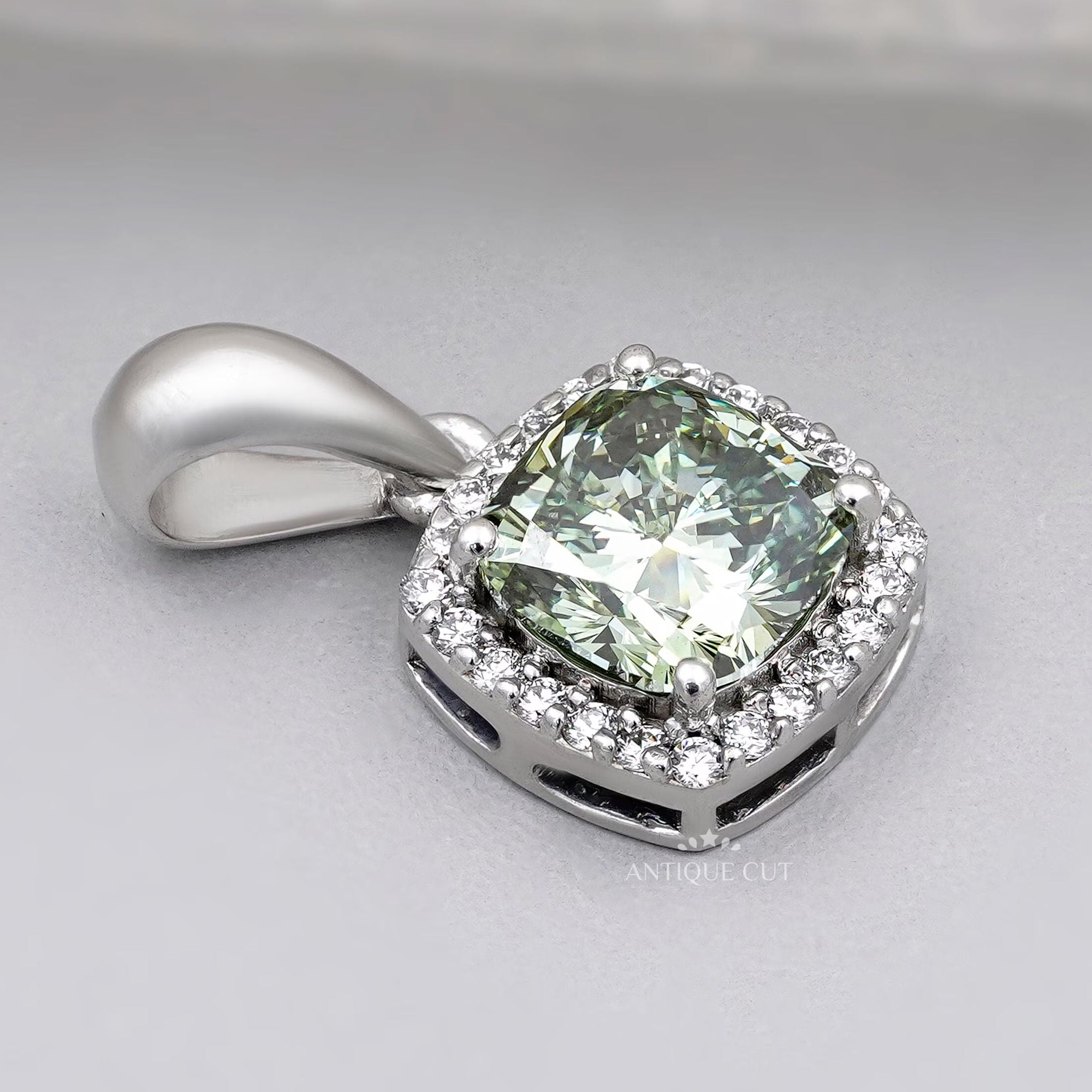 Cushion cut green diamond pendant with halo setting