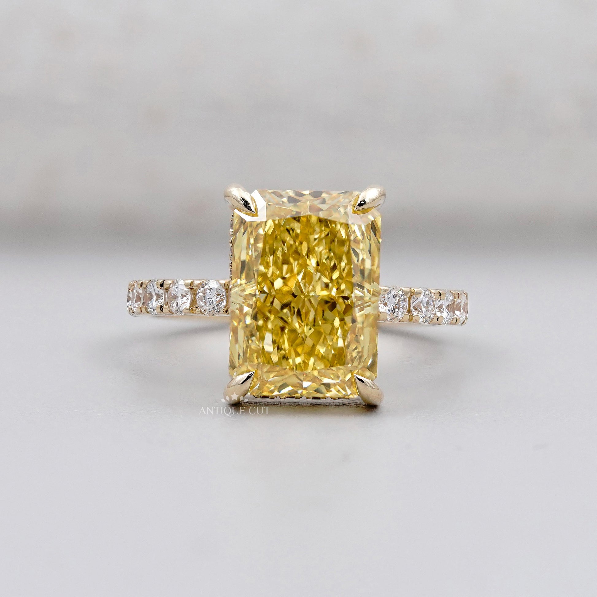 Radiant fancy yellow diamond engagement ring in yellow gold
