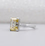 Yellow gold emerald cut diamond ring with side stone