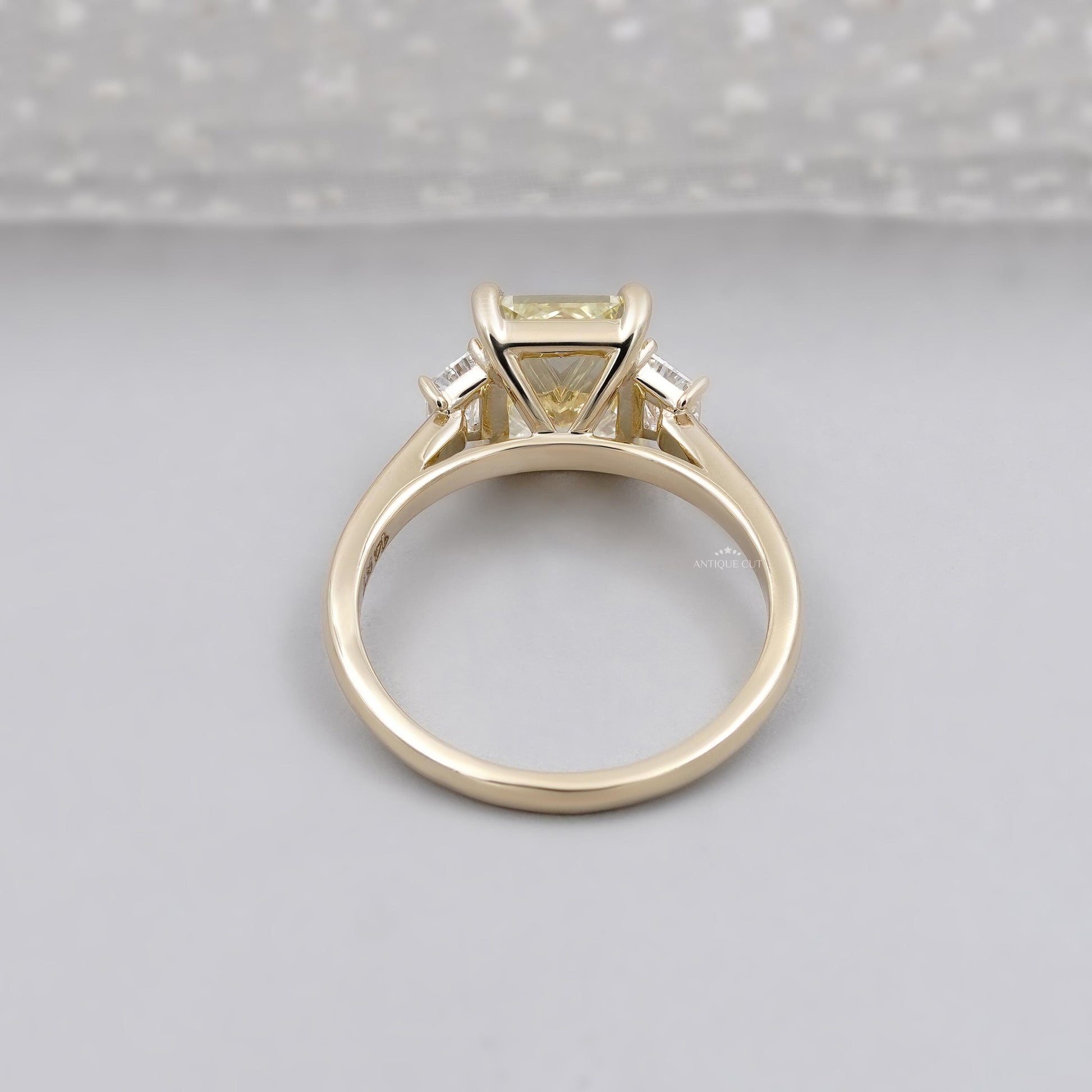 Elegant radiant yellow diamond ring with trapezoid side stones