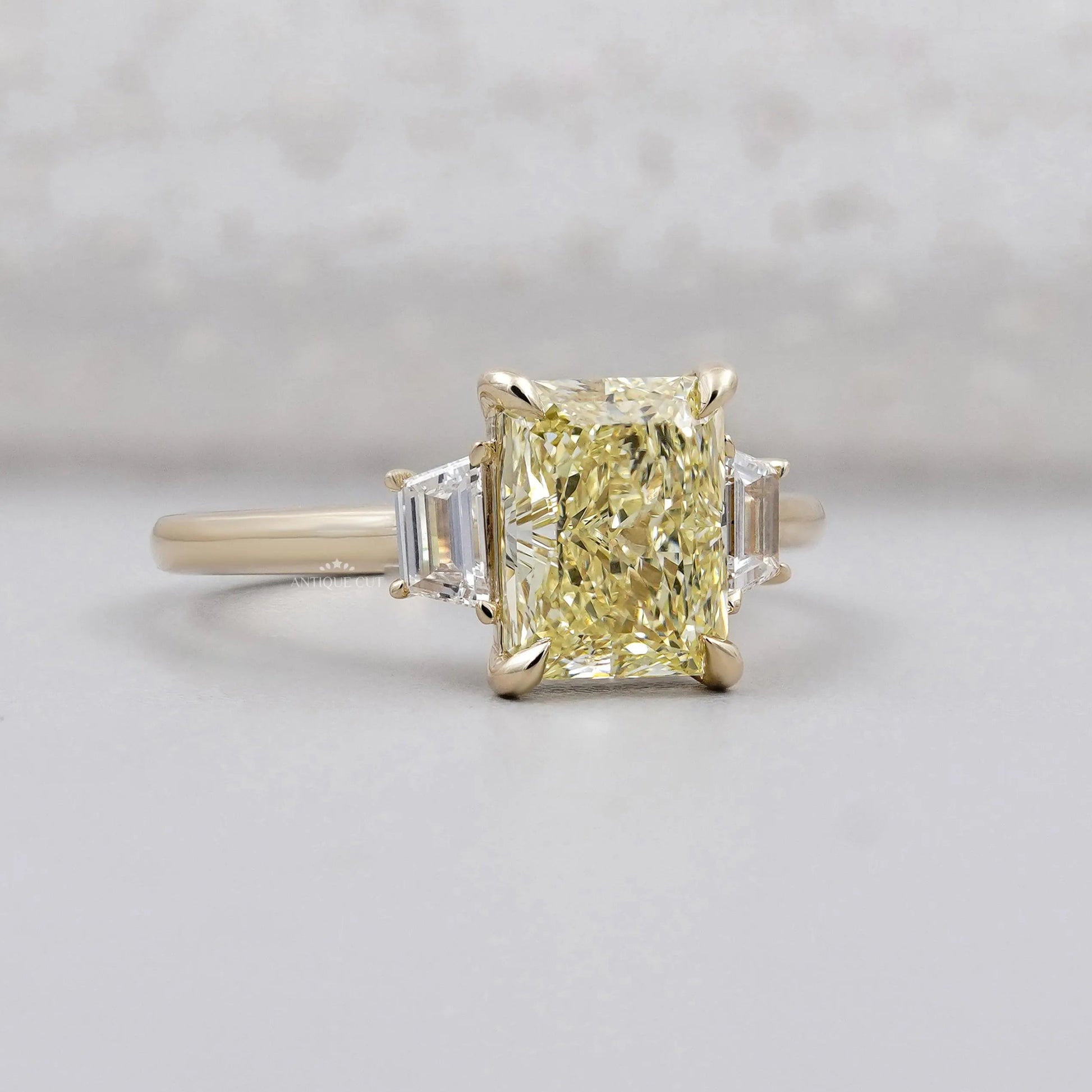Fancy yellow radiant cut diamond ring with trapezoid side stones