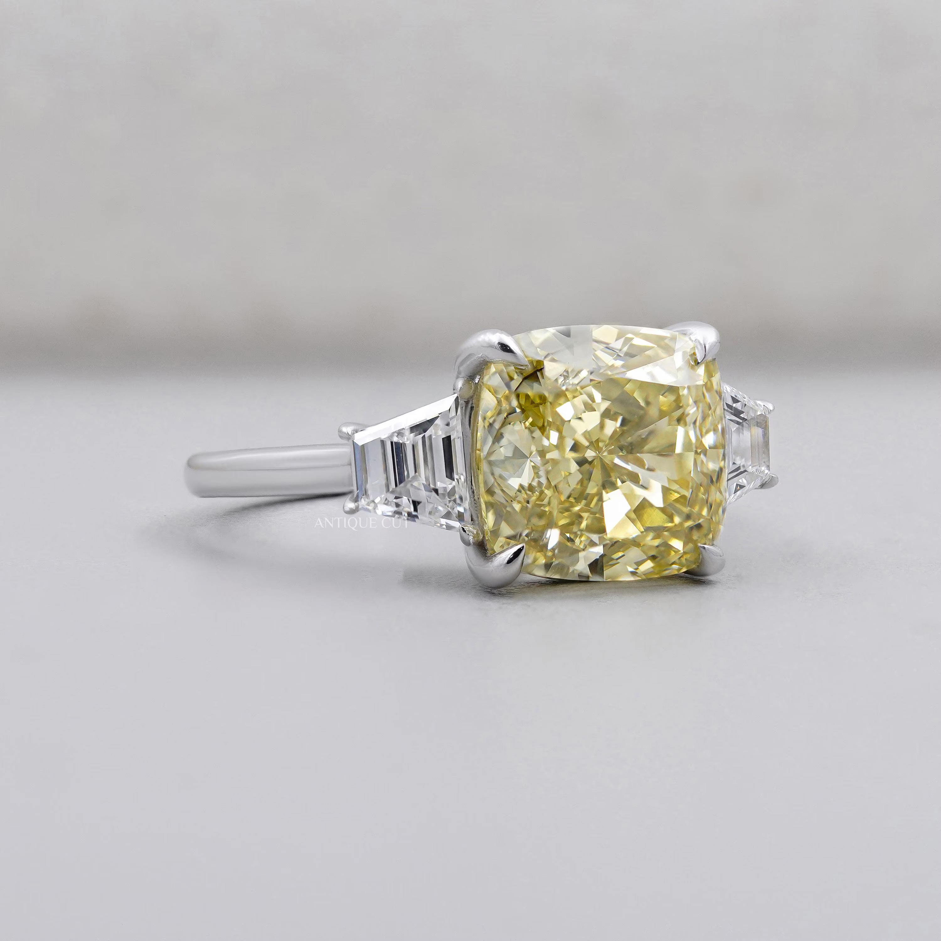 Fancy yellow cushion cut diamond three stone engagement ring