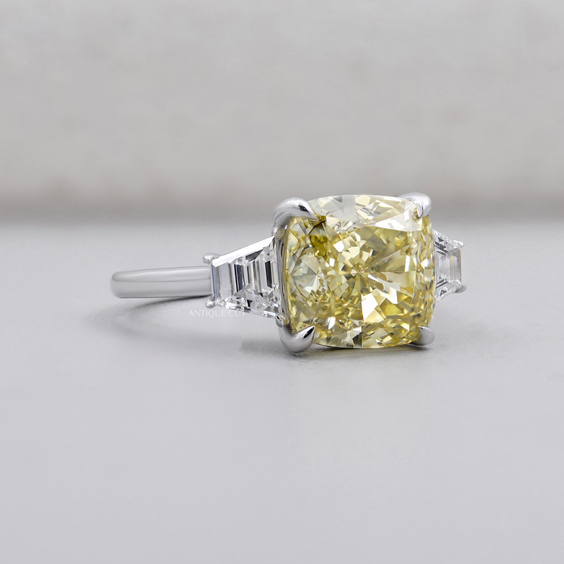 Fancy yellow cushion cut diamond three stone engagement ring