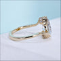 Oval cut diamond bypass engagement ring with round side stone