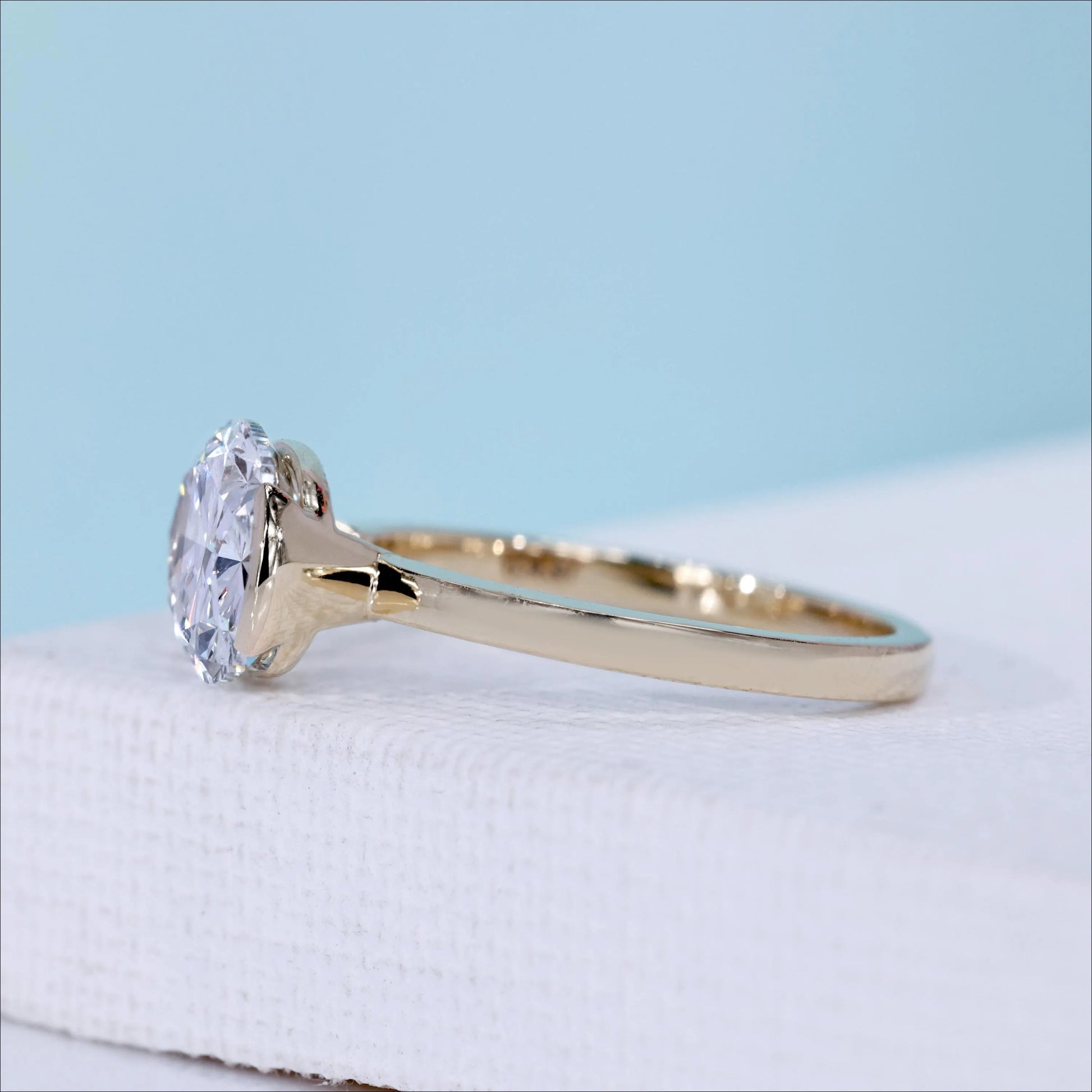 East west oval engagement ring featuring oval cut diamond solitaire