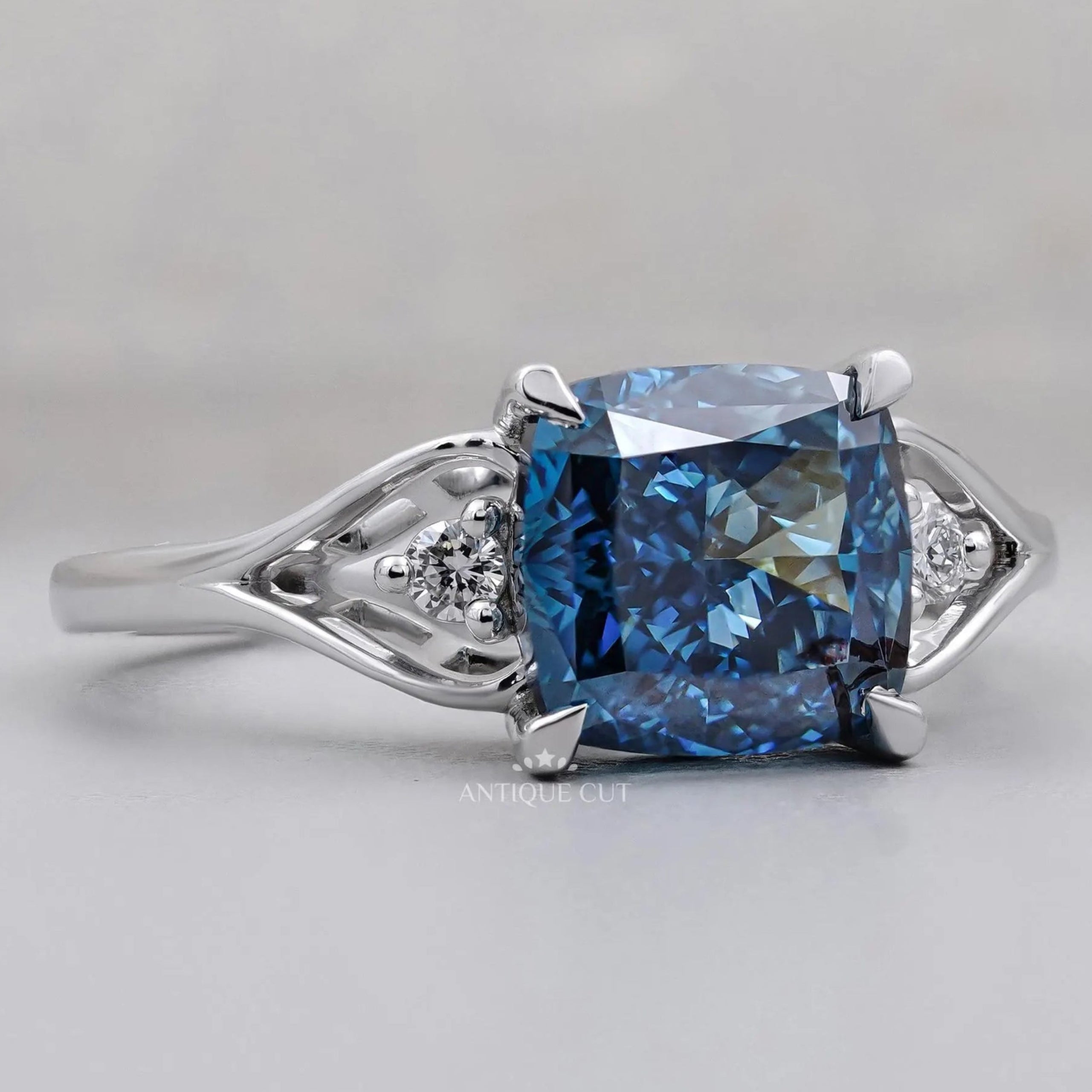 Cushion cut blue diamond ring with round side stones
