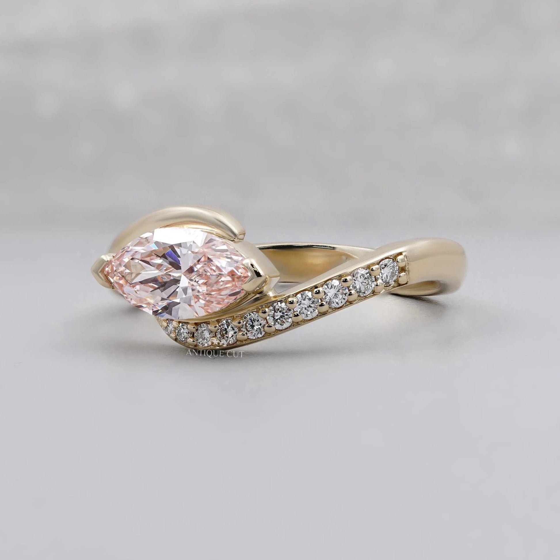 Pink marquise diamond ring with round side stones