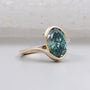 Green oval cut diamond engagement ring with yellow gold bypass setting