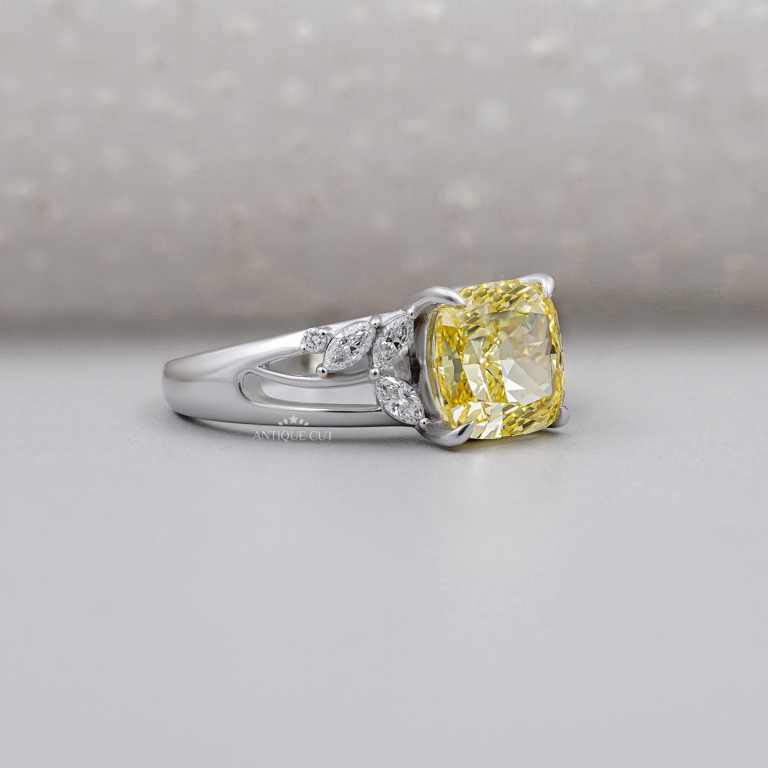 Cushion cut yellow diamond engagement ring with marquise side stones