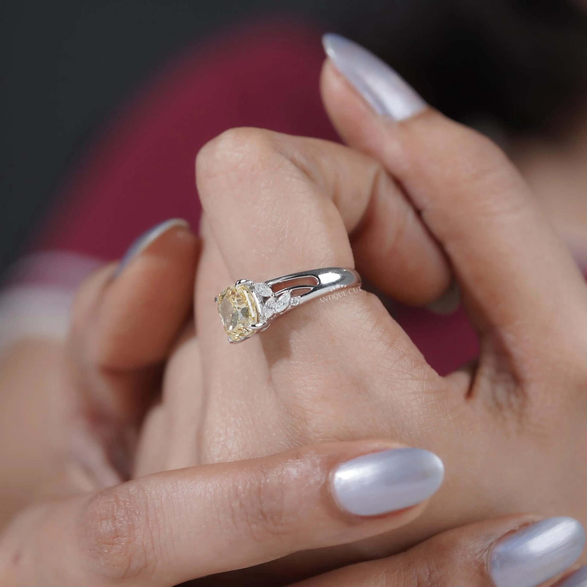 Proposal ring with cushion cut diamond and side stones