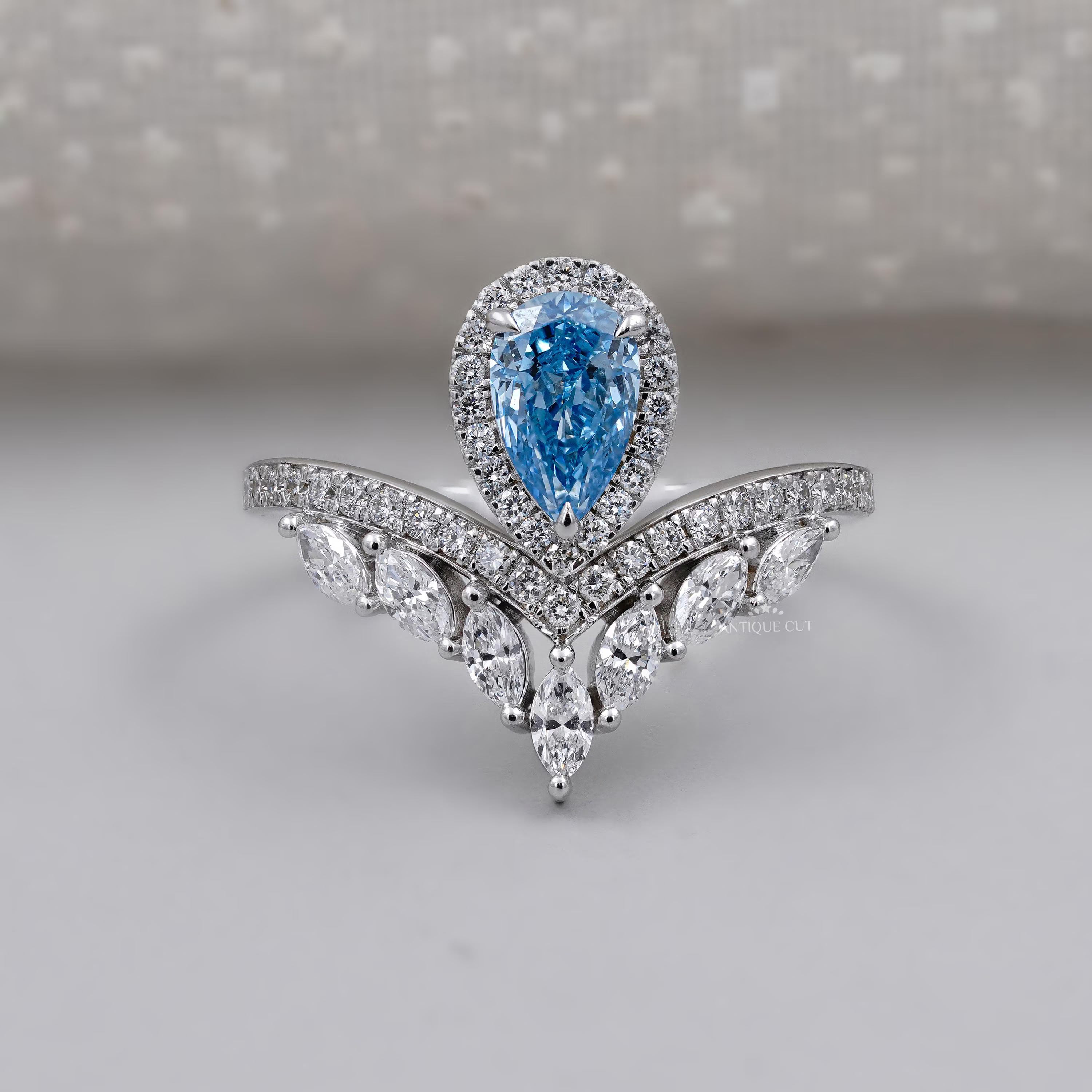 Pear shaped blue diamond ring with chevron marquise band