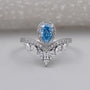 Pear shaped blue diamond ring with chevron marquise band