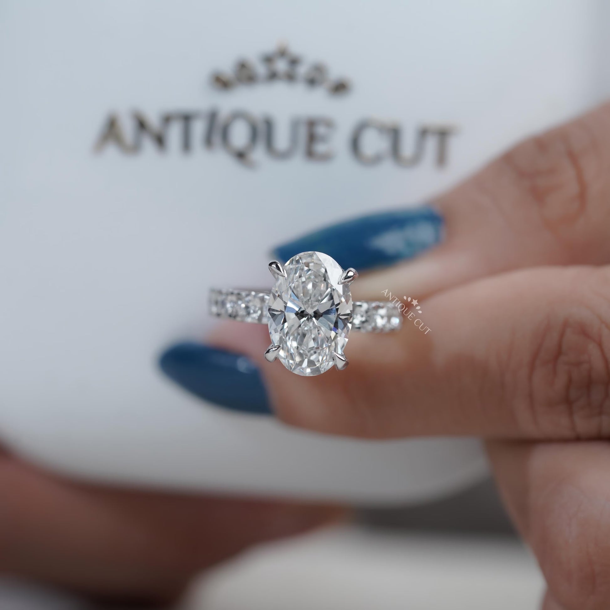 Classic oval diamond engagement ring with white gold pavé band