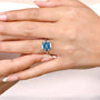 Blue radiant diamond center stone with white gold cathedral band