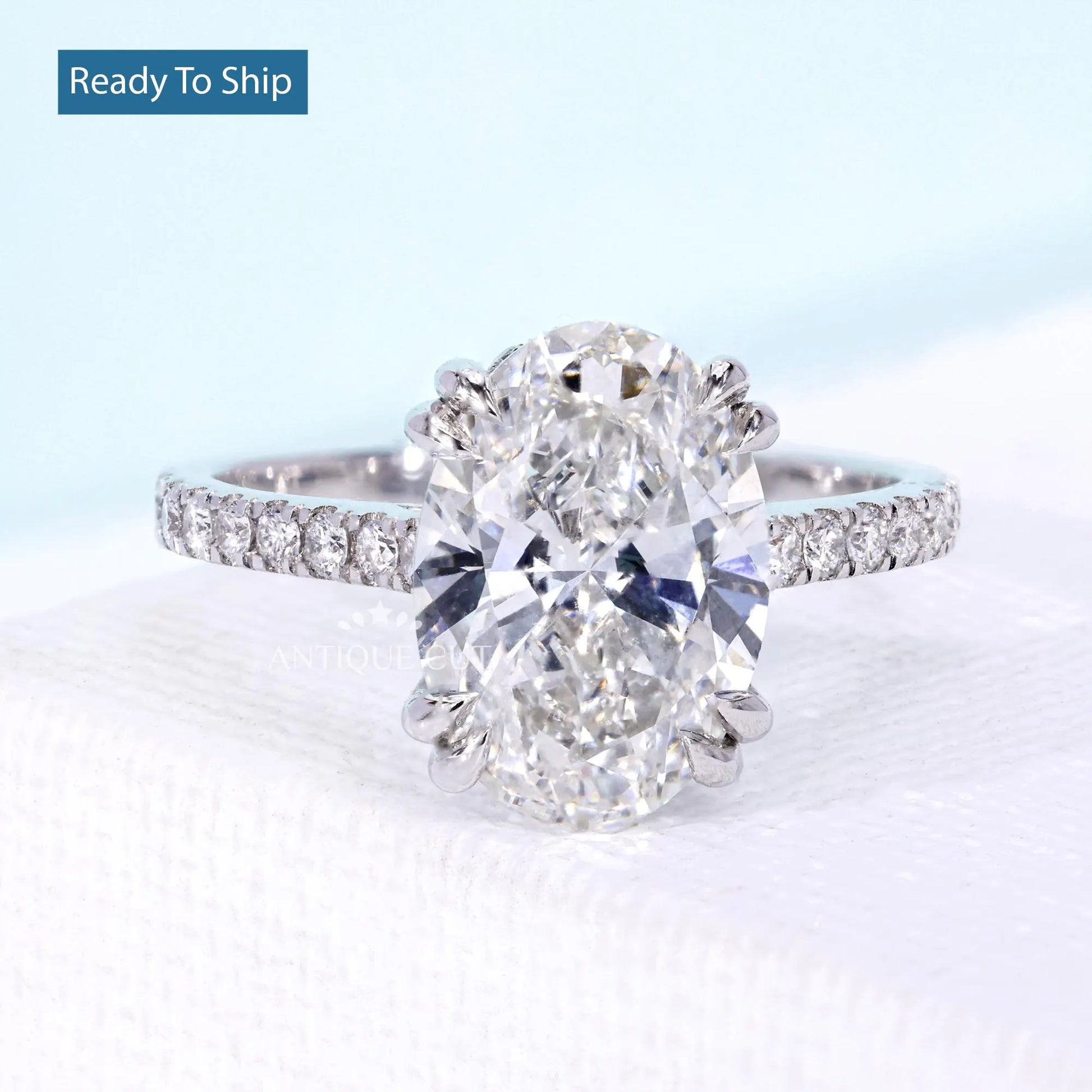 Oval diamond hidden halo engagement ring with white gold cathedral setting