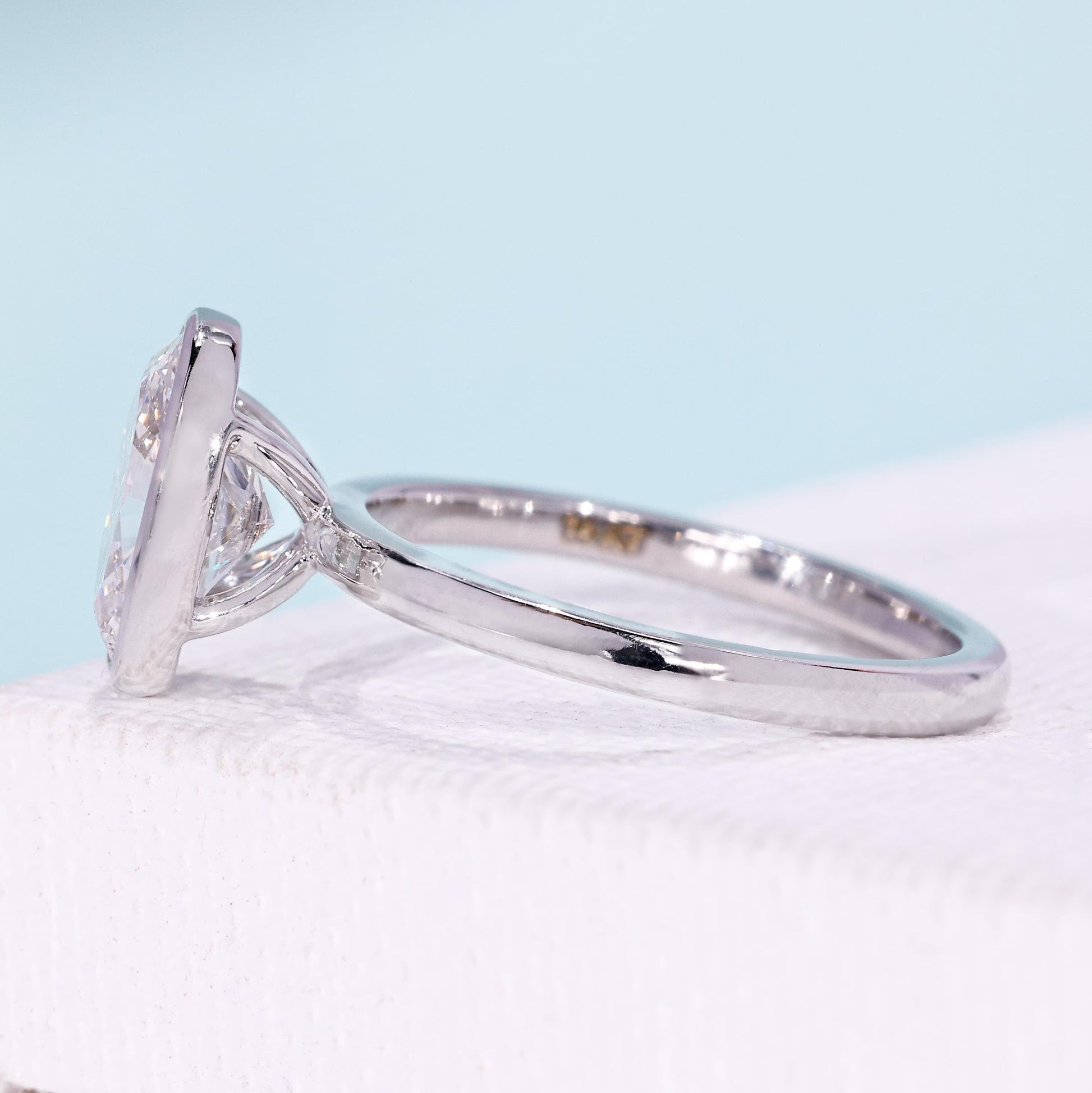 Oval diamond engagement ring with secure bezel setting