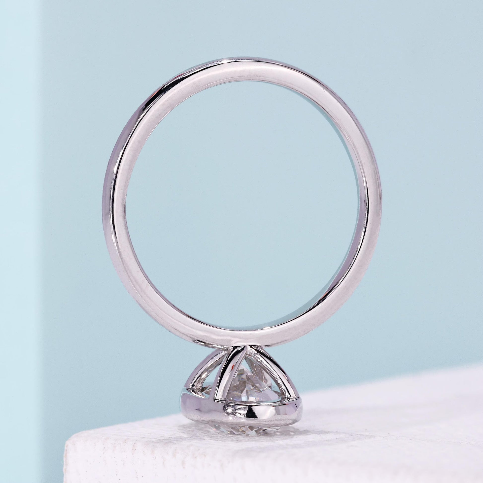 White gold bezel engagement ring with oval center diamond