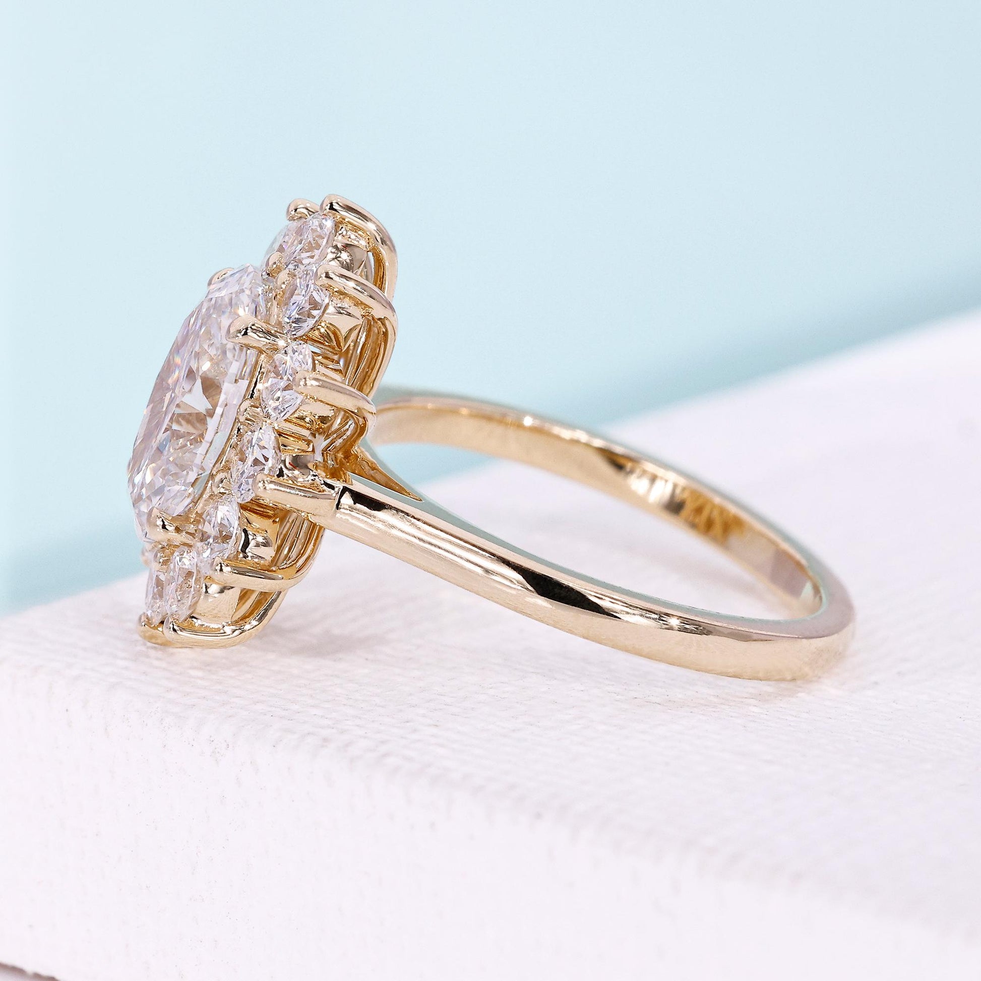 Yellow gold engagement ring with cathedral setting and halo design