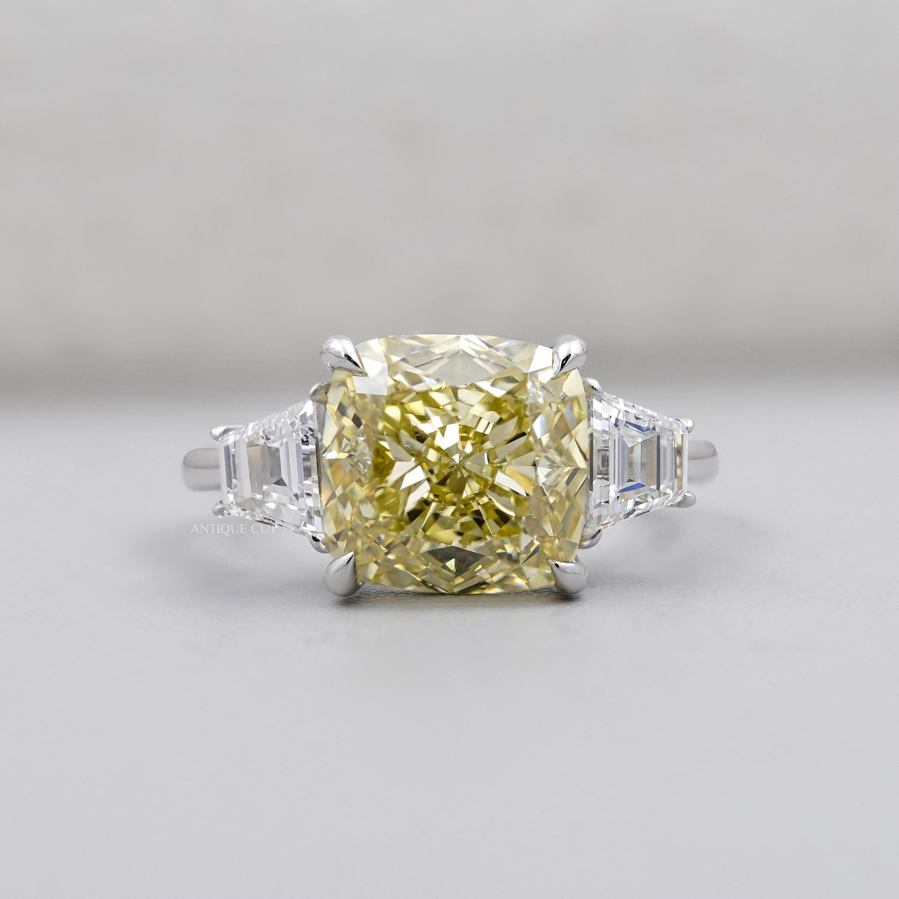 Cushion Cut Fancy Yellow Diamond Three Stone Ring With Tapered Baguette Side Stones IGI Certified