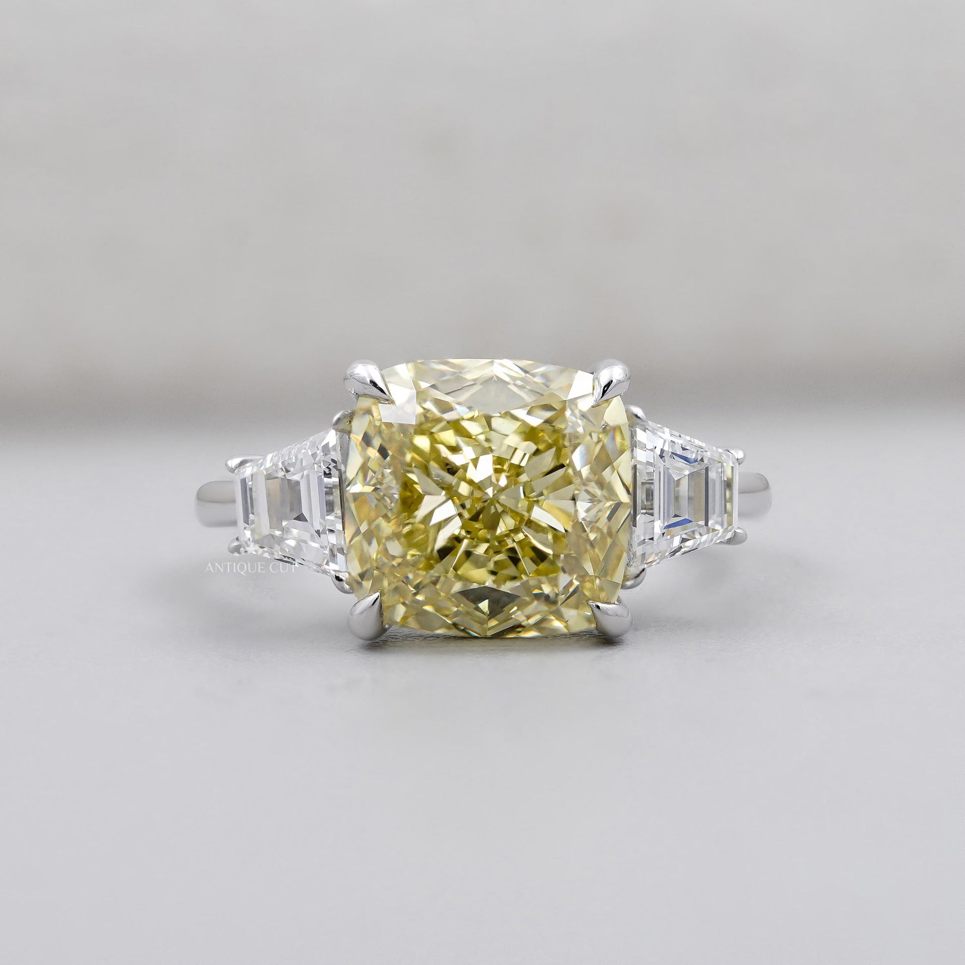Cushion Cut Fancy Yellow Diamond Three Stone Ring With Tapered Baguette Side Stones IGI Certified