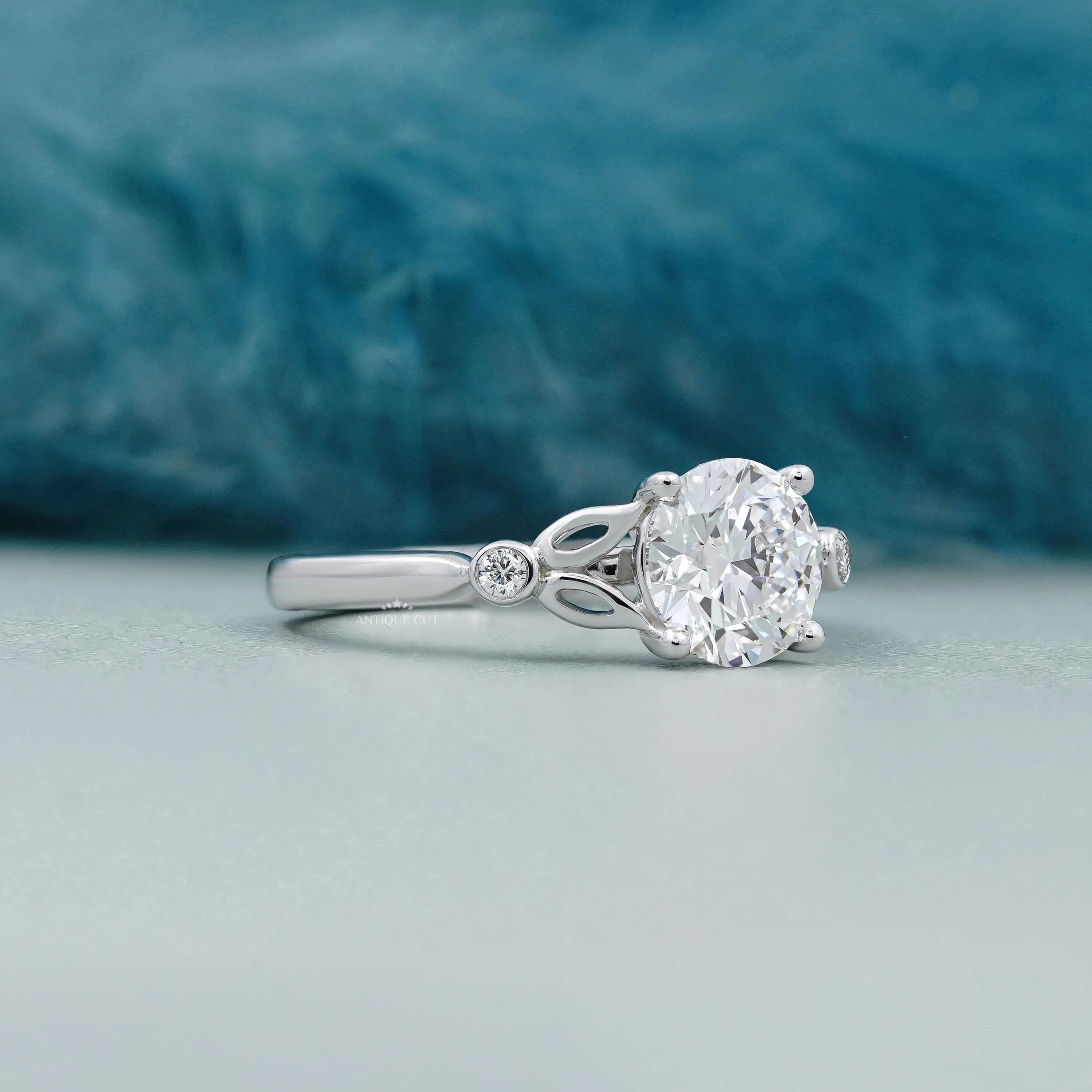 Round cut diamond engagement ring with leaf side accents