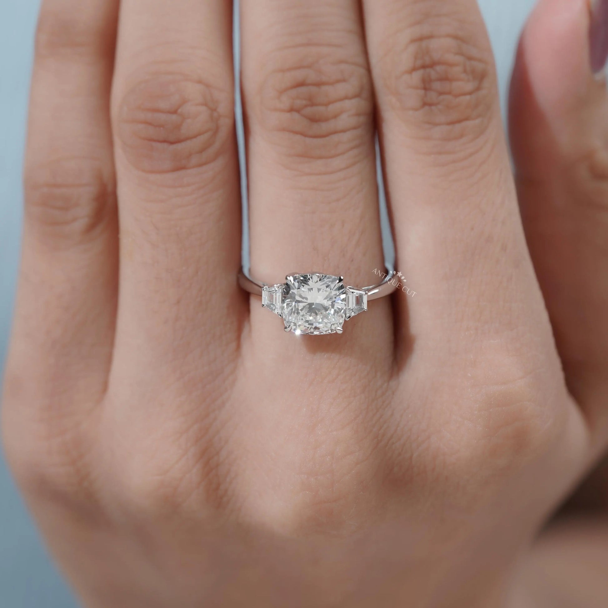 Top view of cushion cut engagement ring with tapered baguette diamonds on each side.