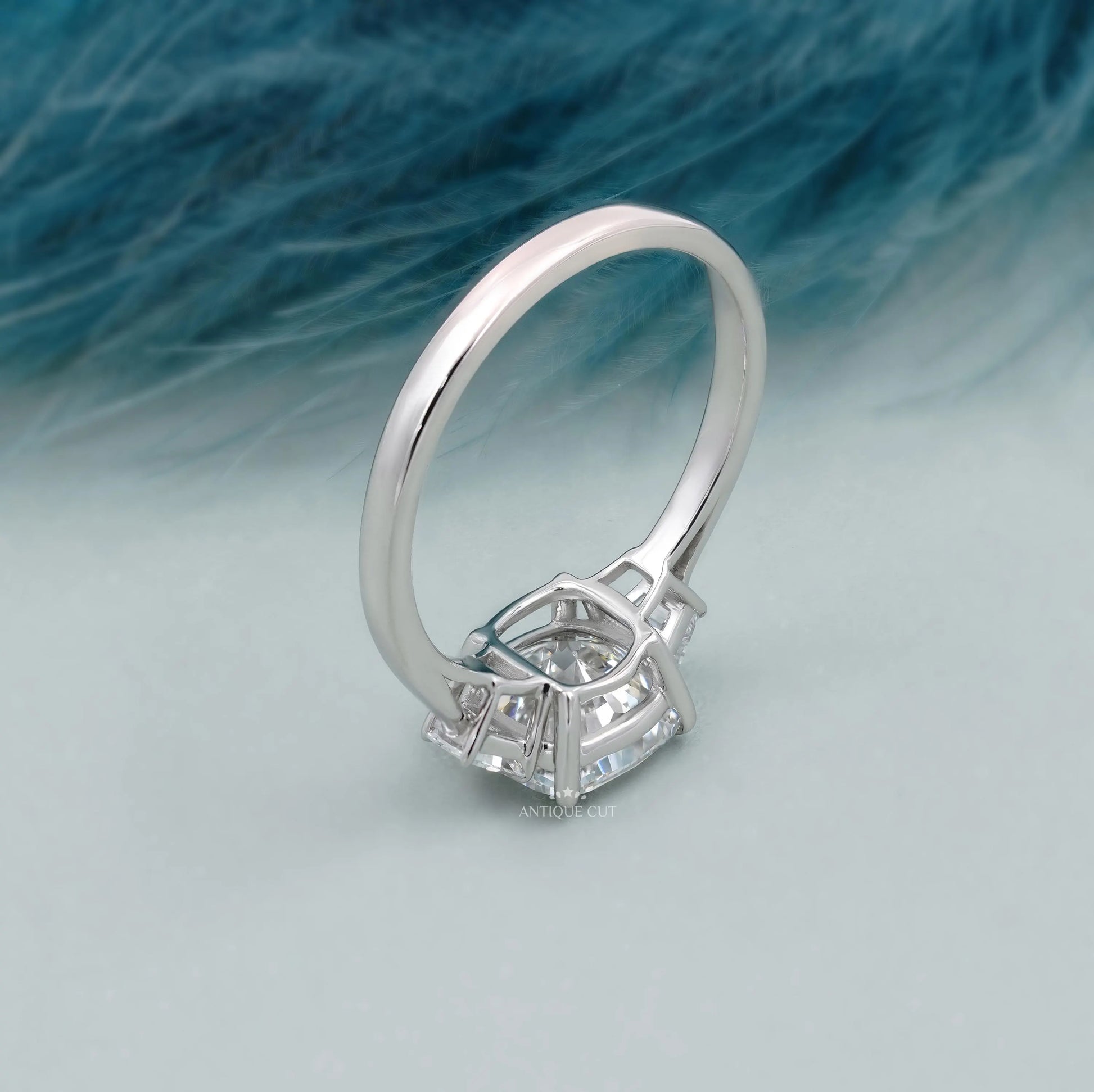 Close-up of cushion cut diamond center with tapered baguette side stones engagement design.