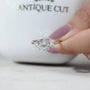 Bridal engagement ring featuring cushion cut center diamond with tapered baguette sides.