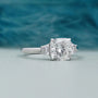 Elegant three-stone engagement ring featuring a cushion cut center and baguette side stones.